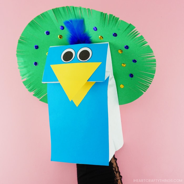 Adult hand inside the peacock puppets showing how to move the beak open and closed.
