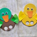 Yellow duck finger puppet with green and brown duck finger puppet laying next to each other on a faux wood background.