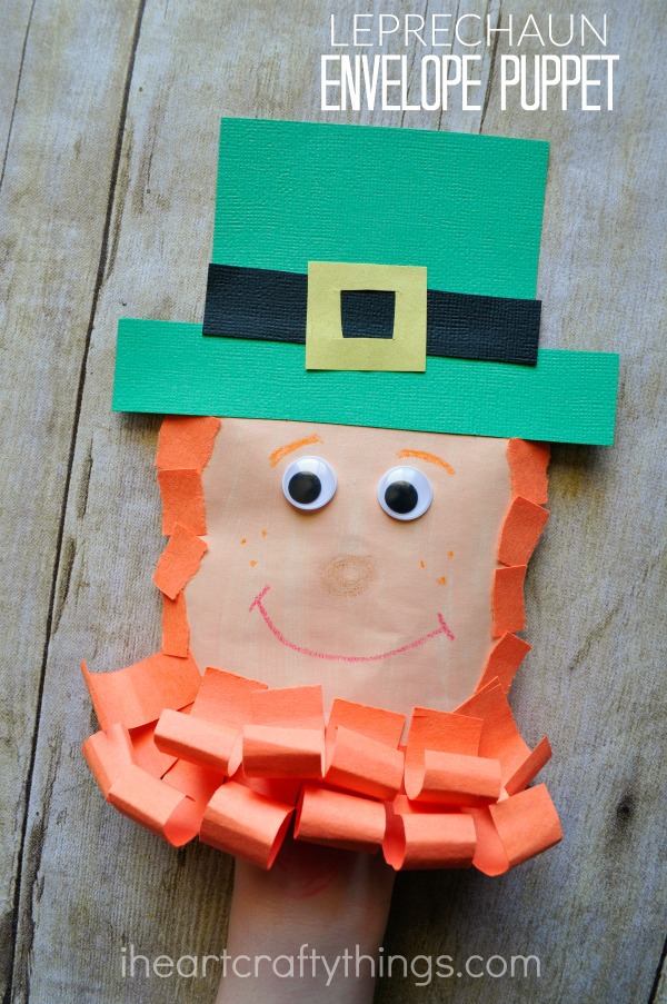 Vertical image of child playing with the leprechaun craft puppet with the words "Leprechaun Envelope Puppet" in the top right corner.