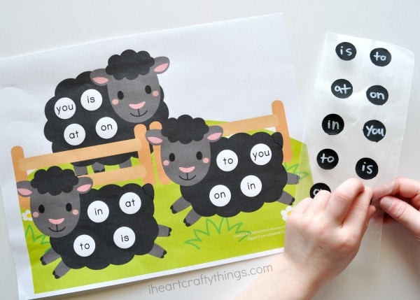 Child peeling a sight word sticker off the page and placing it on the sight words printable.