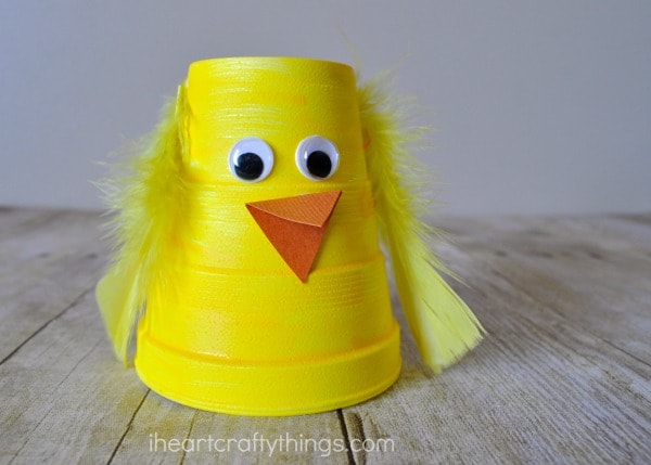 Close up horizontal image of yellow painted foam cup made into a chick craft for kids.