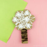 Square close up image of yarn wrapped winter tree craft.