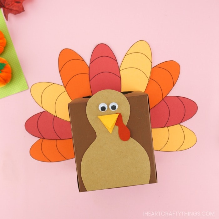 Square image of thankful turkey box laying face up on a pink background.