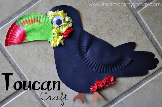 Toucan craft made by child laying on a brown tile background.