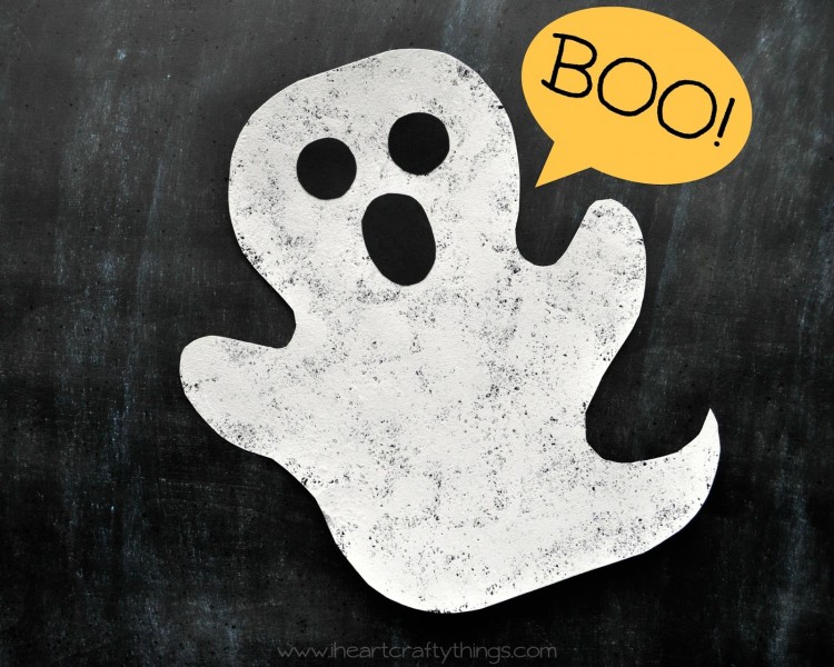 Horizontal image of sponge painted ghost craft laying on a black chalkboard background with "BOO!" written in the top right corner.