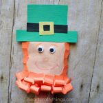 Close up image of child with their hand inside the leprechaun envelope puppet