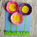 Square image of flowers craft made out of paper doilies and colored paper.