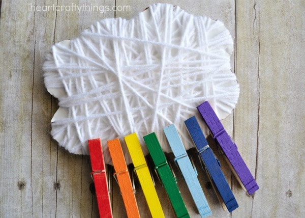 Close up image of the yarn wrapped cloud and rainbow clothespins put together.