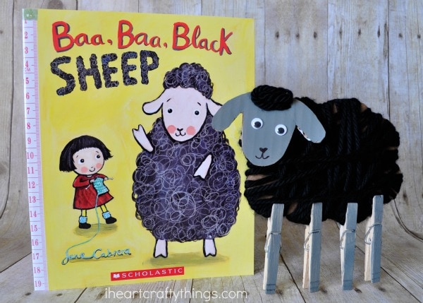 Yarn wrapped sheep craft standing next to book titled "Baa Baa Black Sheep".