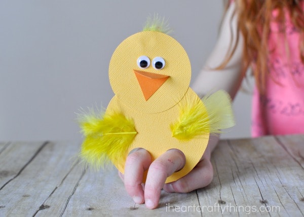 Horizontal image of child playing with a chick finger puppet.