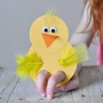child playing with a chick finger puppet craft