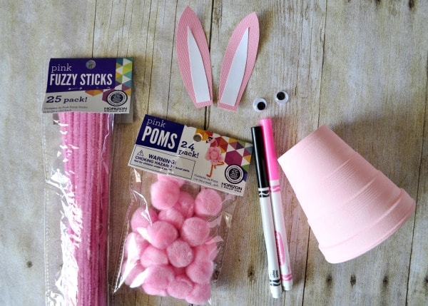 supplies needed to make the foam cup bunny craft laid out on a faux wood background.