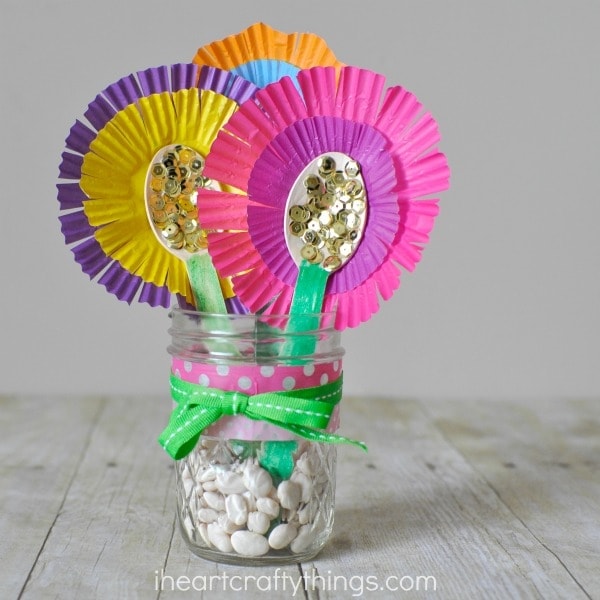 close up image of mother's day flower bouquet gift made out of wooden spoons and cupcake liners in a mason jar.