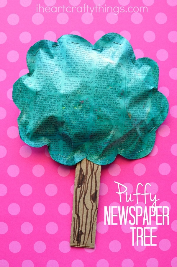 vertical image of puffy newspaper tree craft on a pink background.