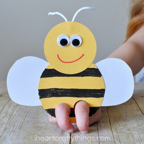 close up image of child using their fingers to play with a bee finger puppet