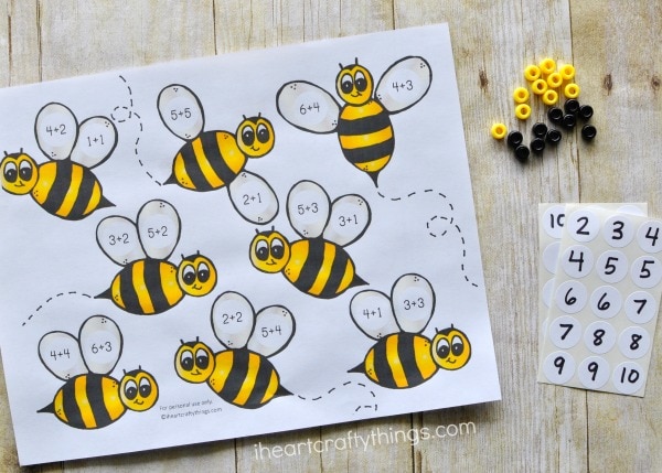 Printed bumblebee preschool math printable laying out with number stickers and black and white pony beads.