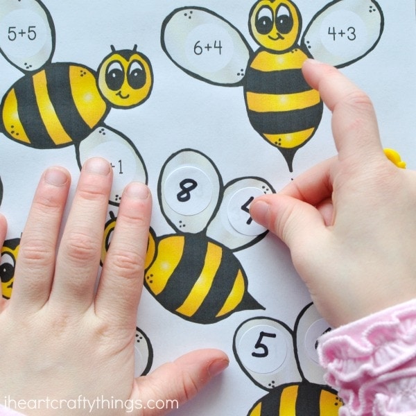 close up image of child placing a sticker on the bumblebee math printable