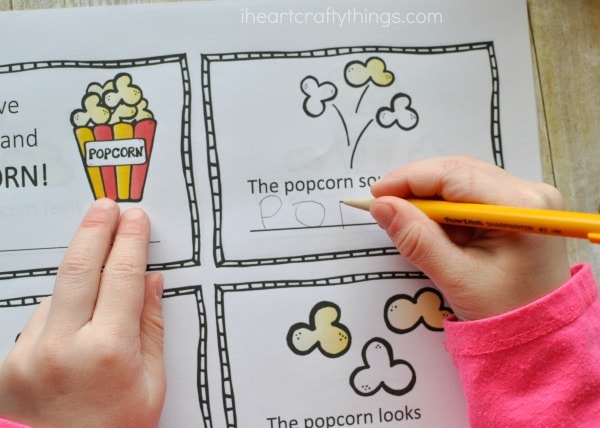 Child using a pencil to fill in the writing prompts in the five senses mini book.