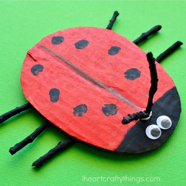 ladybug craft made out of cardboard, sticks and paint.