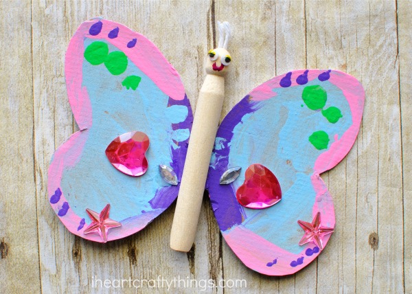 Child made wood peg doll butterfly craft.