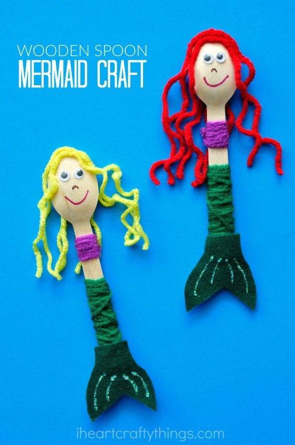 Vertical close up image of two wooden spoon mermaid puppets, one with blonde hair and one with red hair.