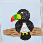 This cupcake liner toucan craft is simple to make and the brightly colored beak gives the craft such a fun pop of color. Fun bird craft for kids, cupcake liner crafts, summer kids craft and preschool crafts.