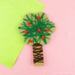 Square close up image of yarn wrapped apple tree craft for preschoolers to make.