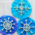 Painted coffee filters, pinwheel pasta and paper straws come together to create awesome texture in this fun kids snowflake craft. Fun winter craft for kids, preschool craft, and symmetry craft for kids.
