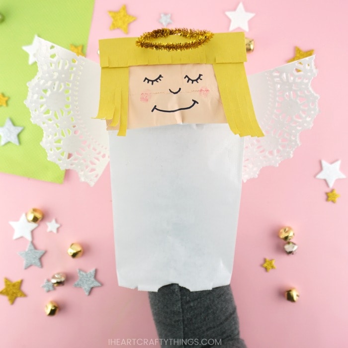 Close up image of how to place your hand and arm inside the paper bug angel to use it as a puppet.