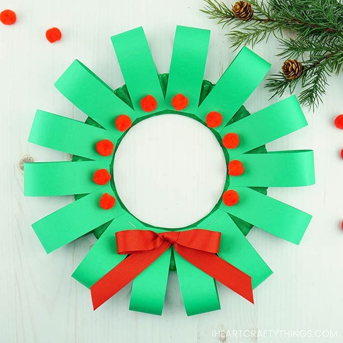 This paper plate Christmas wreath craft is super easy to make and is perfect for kids of all ages. Fun paper plate Christmas craft for kids.