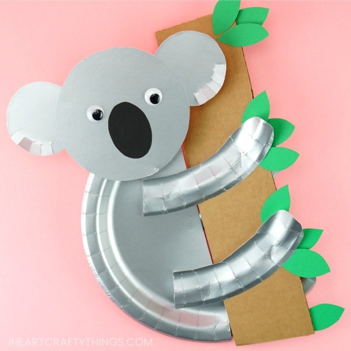 silver paper plate koala craft holding cardboard tree branch with green leaves
