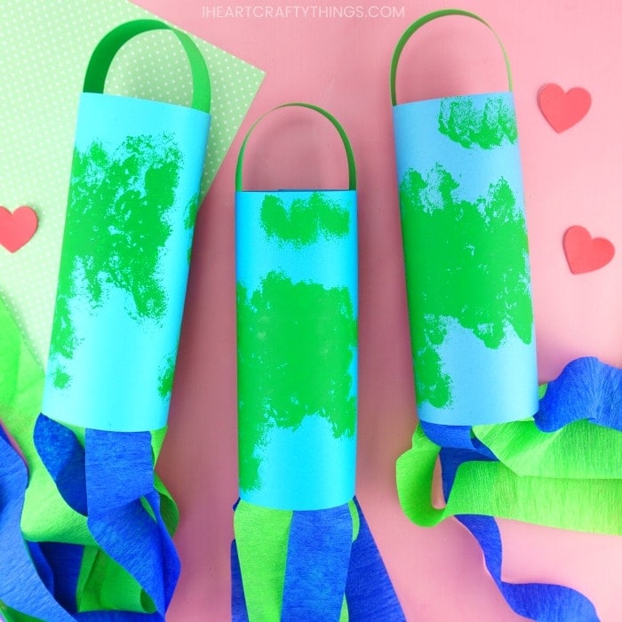 three earth day windsocks laying flat on a pink background