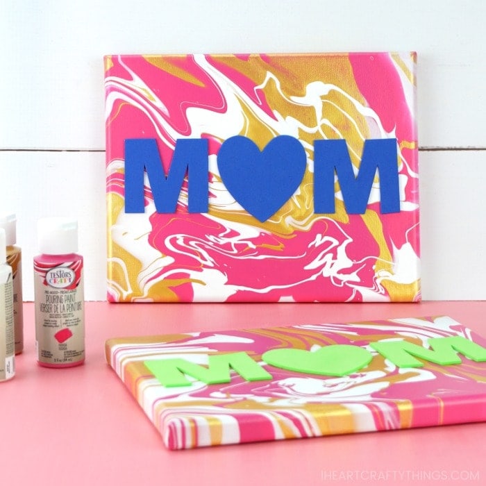 finished Mother's Day paint pouring art propped against a white shiplap background