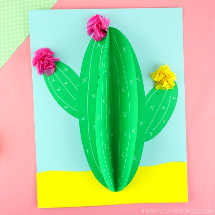 3d paper cactus craft laying flat on a pink background