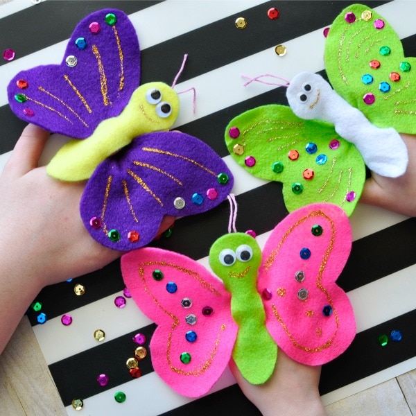 Square image of three children playing with butterfly finger puppets