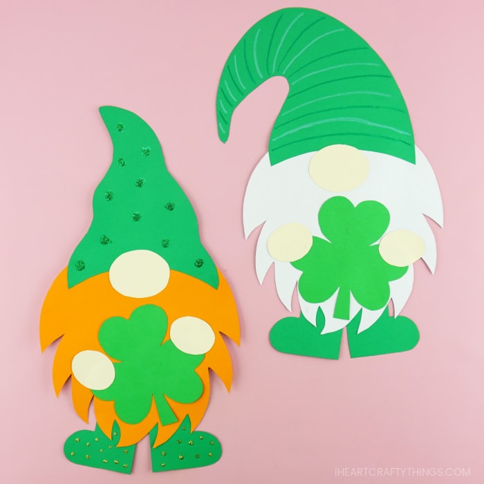 Two St. Patrick's Day gnome crafts laying side by side, one with an orange beard and one with a white beard.