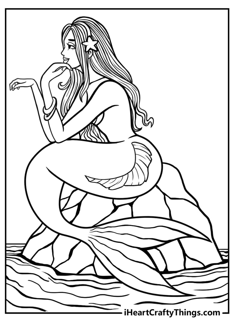 Free printable of a mermaid sitting on a rock with her head resting on her hand and looking into the distance