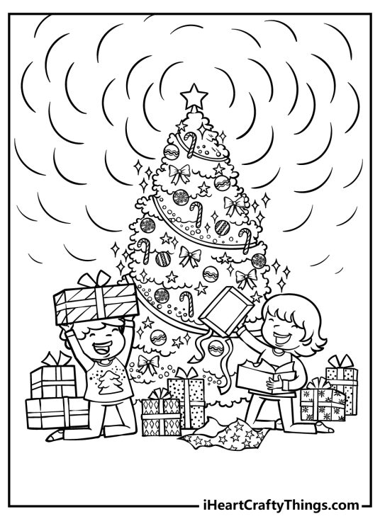 Children unpacking presents by the Christmas tree