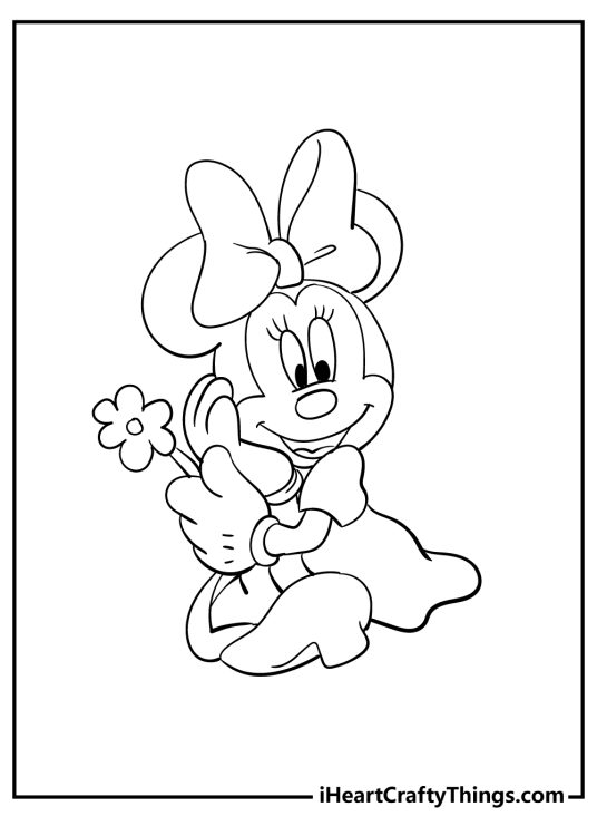 Printable sheet featuring cheerful Minnie Mouse sitting outdoors holding a pretty flower