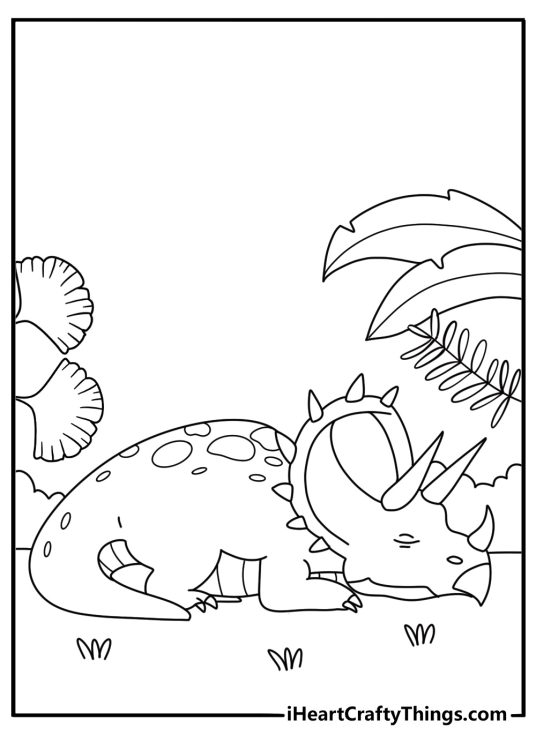 A small triceratops rests beside broad prehistoric leaves