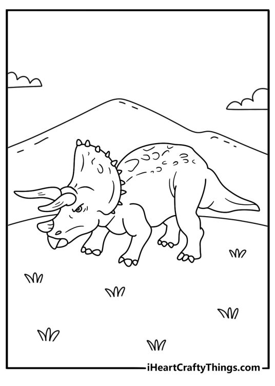 A triceratops lowers its horns toward a charging predator
