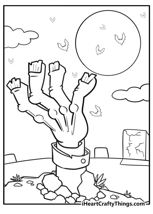 Zombie hand reaching out from the ground at night